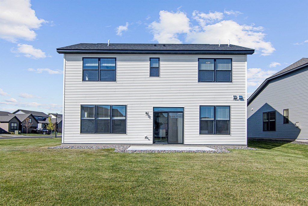 a home with white siding and a gray roof