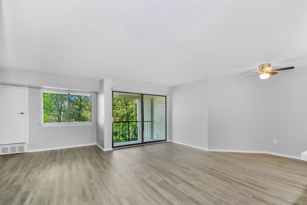 an oversized living room with a sliding glass door to a balcony