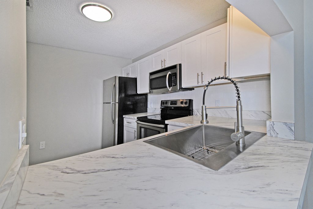a kitchen with white cabinets and a sink