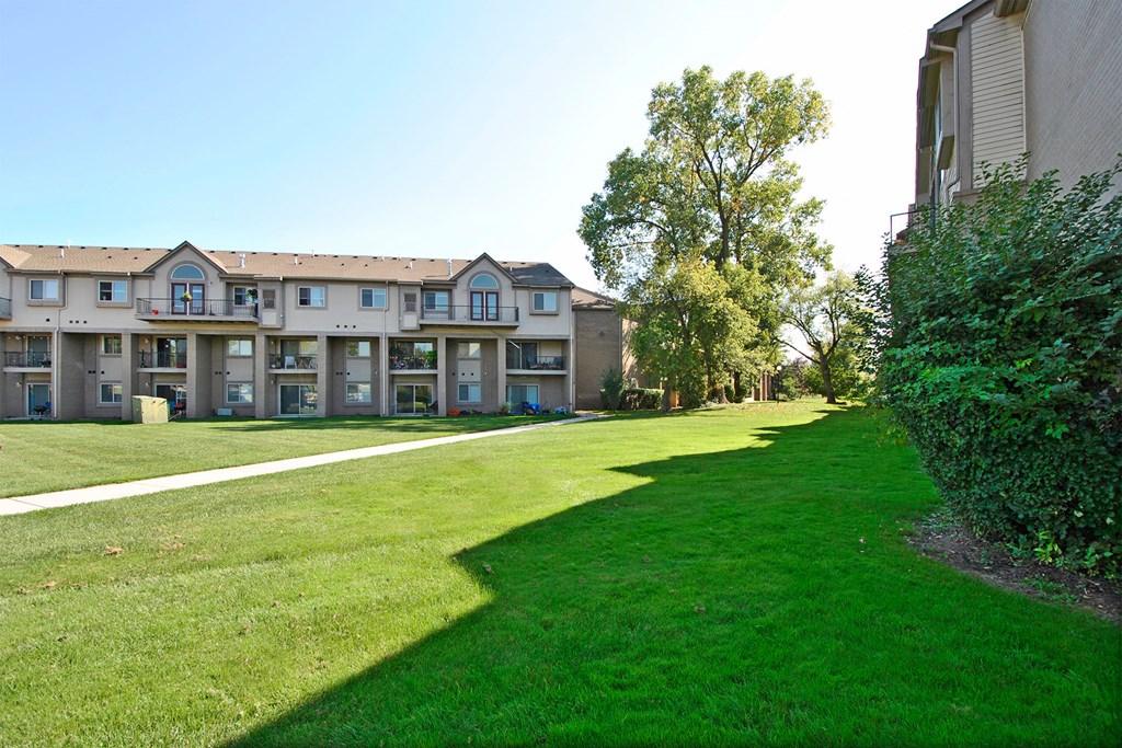 a green lawn in front of an apartment building
