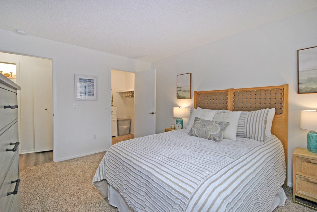 A bedroom with a large bed and a wooden headboard.