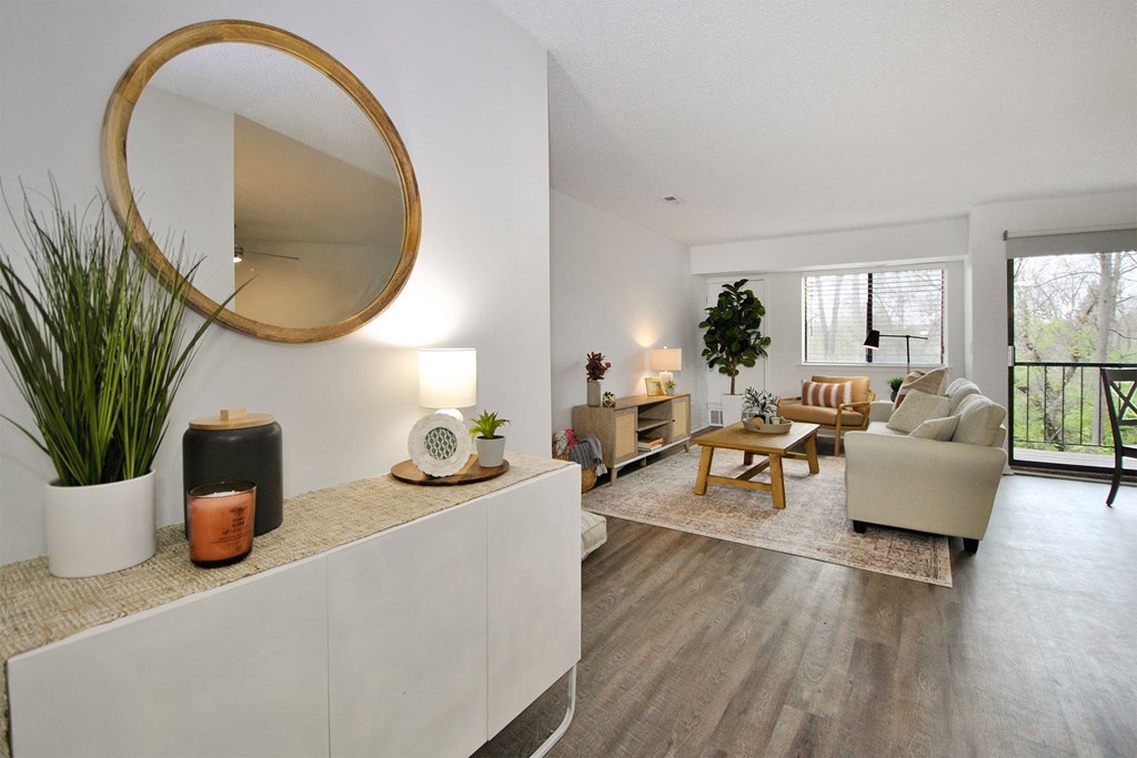 A living room with a large mirror on the wall and a potted plant on the table.