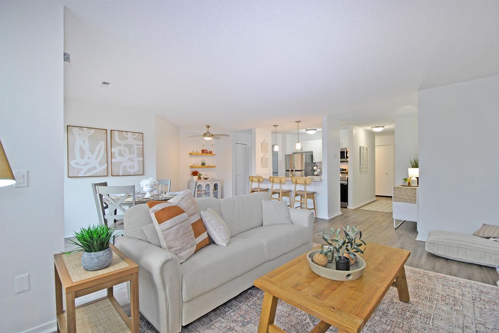 A living room with a couch, a table, and a plant.
