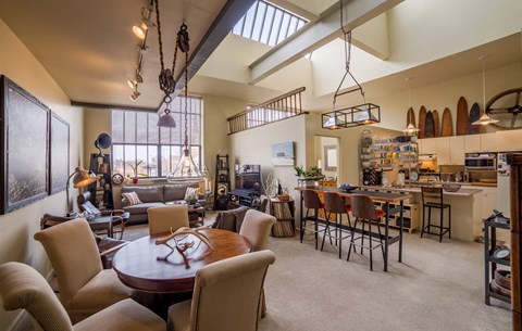 A well-lit, spacious open-plan living and dining area with a large table and chairs.
