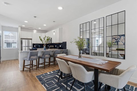 A dining room with a wooden table and chairs.
