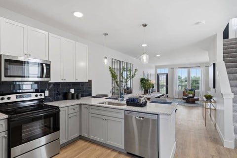 A modern kitchen with a stainless steel oven and a wooden floor.