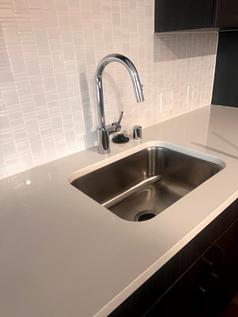 A modern kitchen sink with a chrome faucet.