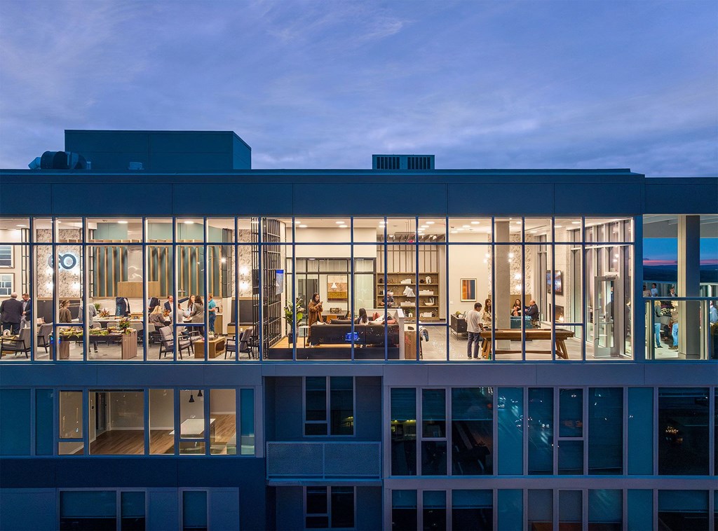 a view of a building with glass windows at dusk