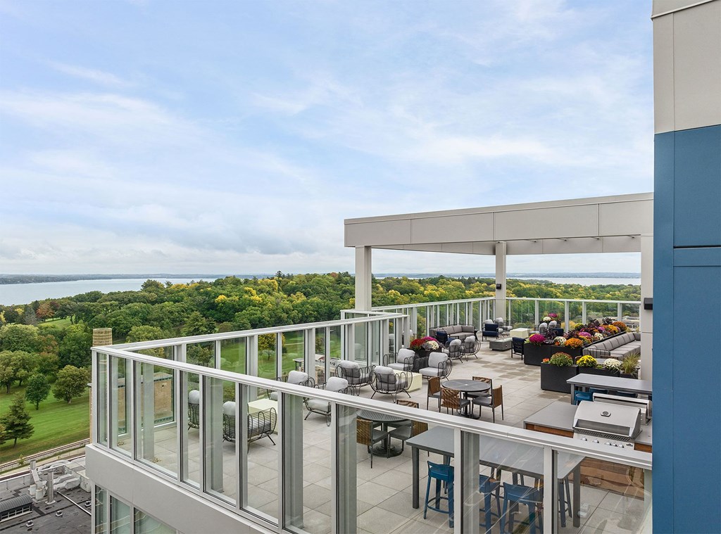 a balcony with tables and chairs and a view of the water