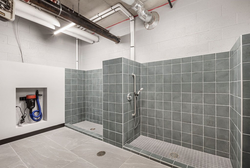 a shower in a room with gray tiles