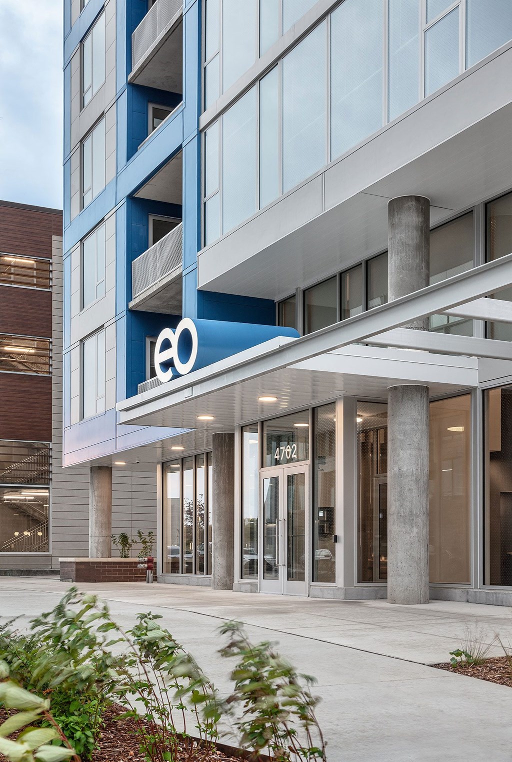 a building with a blue and white facade and a sidewalk