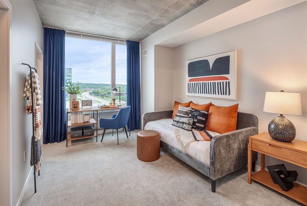 a bedroom with a bed and a desk with a window