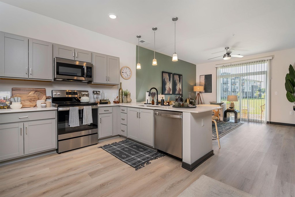 A kitchen with a wooden floor and stainless steel appliances.