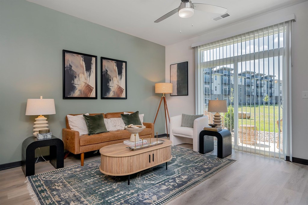 A living room with a couch, a chair, a table, and a rug.