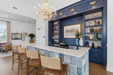 A kitchen with a blue backsplash and a chandelier.