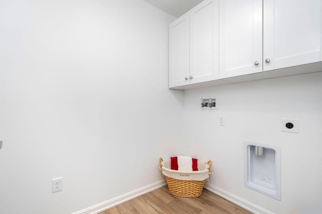 a laundry room with white cabinets and a washer and dryer