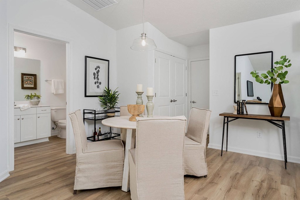 a dining room with white walls and a wooden floor