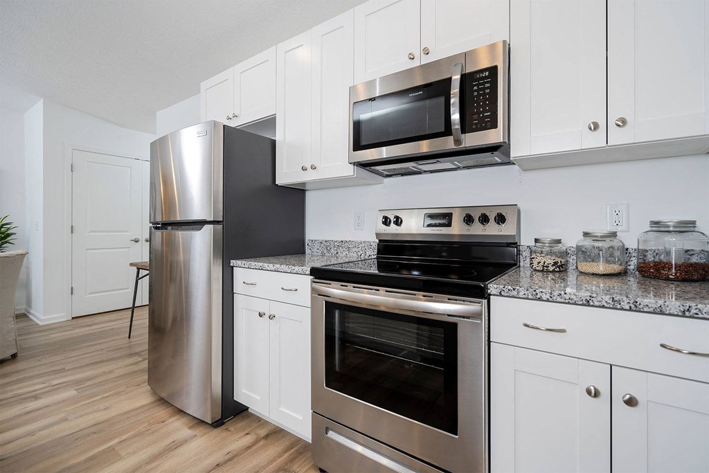a kitchen with white cabinets and stainless steel appliances