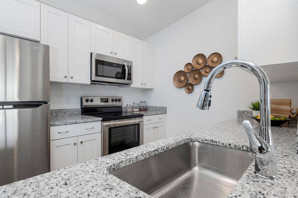 a kitchen with white cabinets and granite countertops