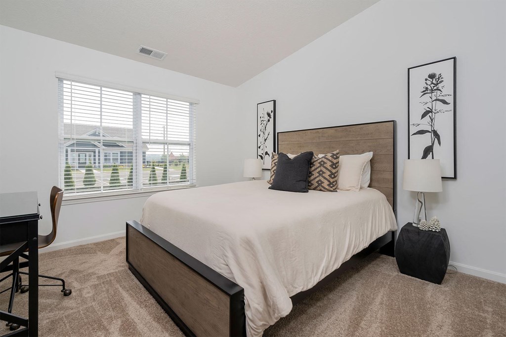 a bedroom with a bed and a desk with a chair