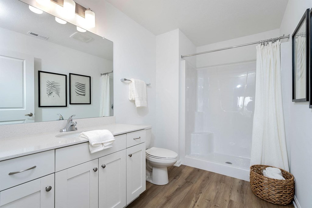 a bathroom with white cabinetry and a white shower curtain
