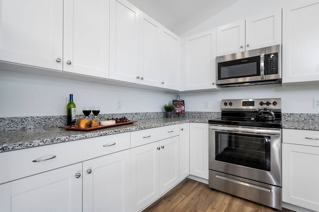 a kitchen with white cabinets and stainless steel appliances