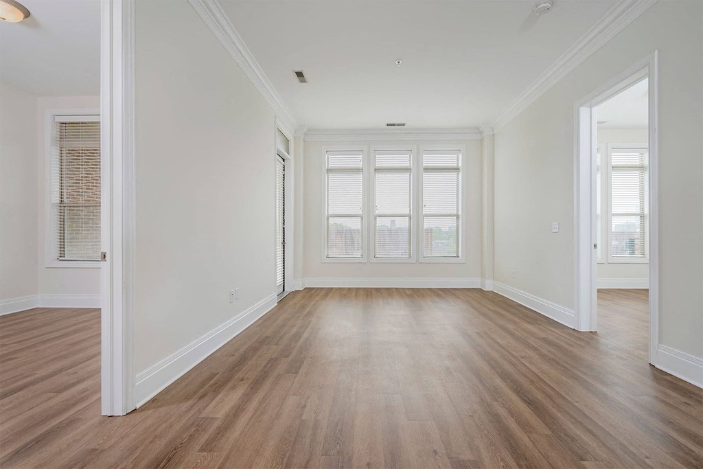 a bedroom with hardwood floors and white walls