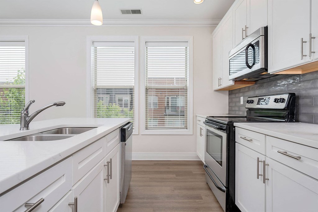 a kitchen with white cabinets and stainless steel appliances