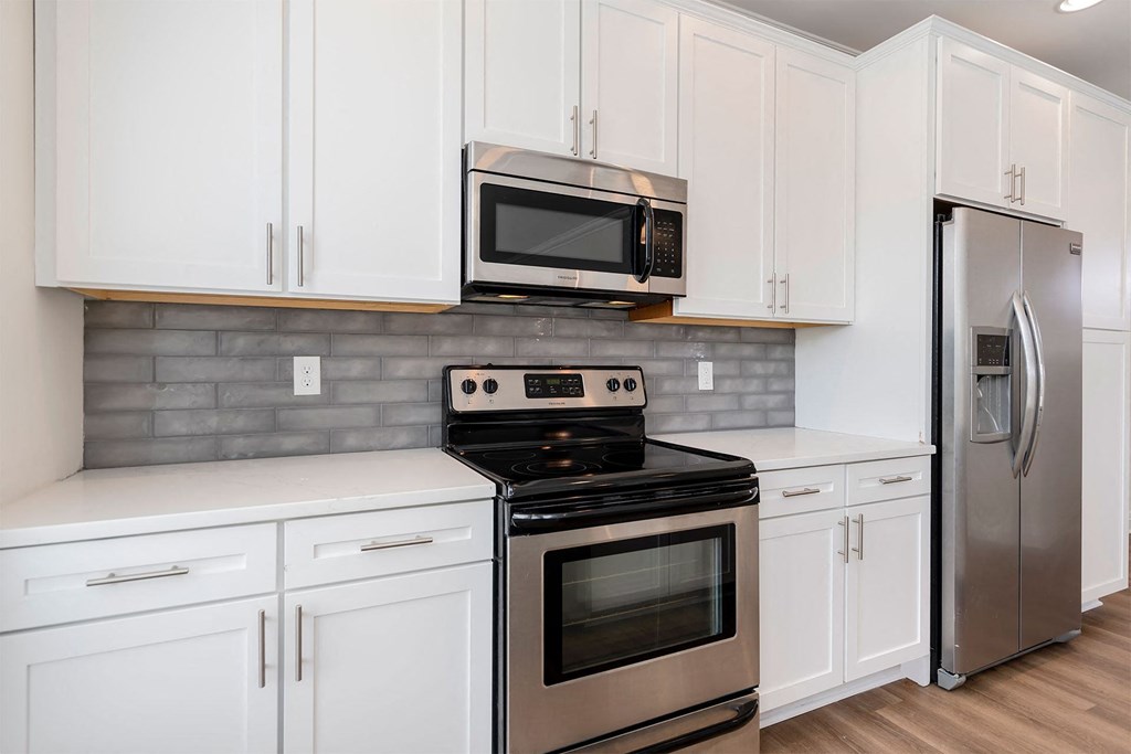a kitchen with white cabinets and stainless steel appliances