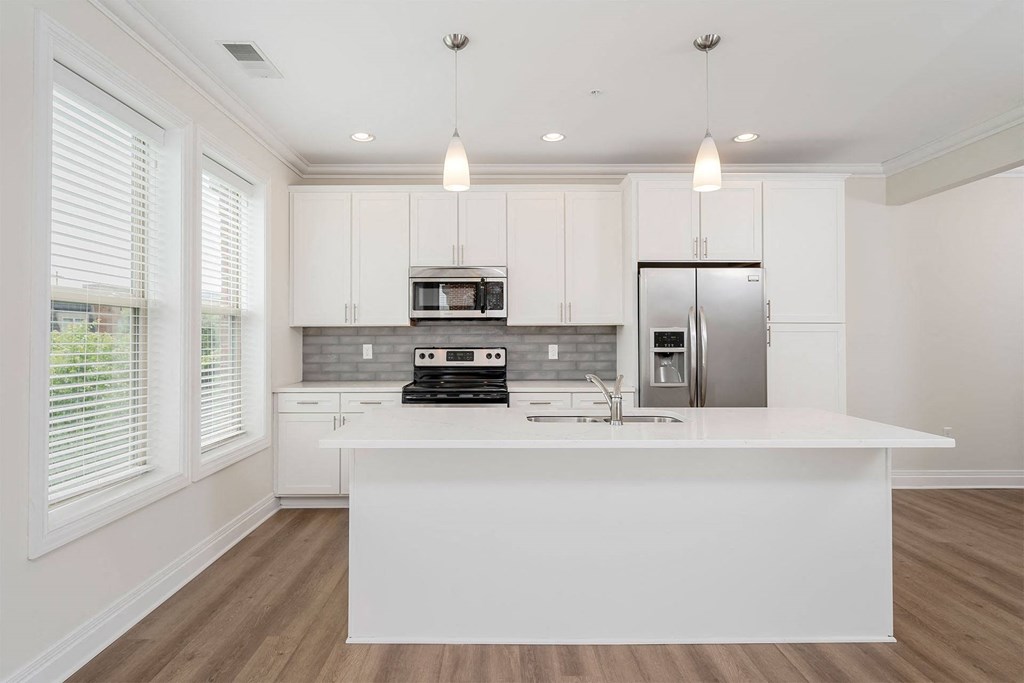 a kitchen with white cabinets and a large island
