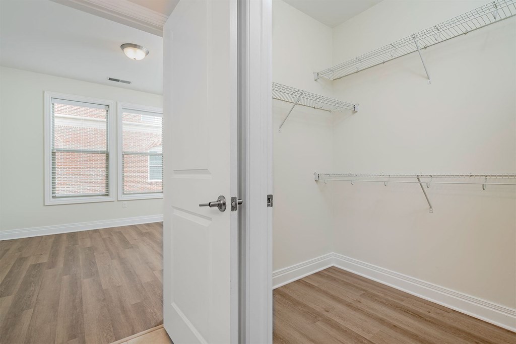 a bedroom with white walls and hardwood floors