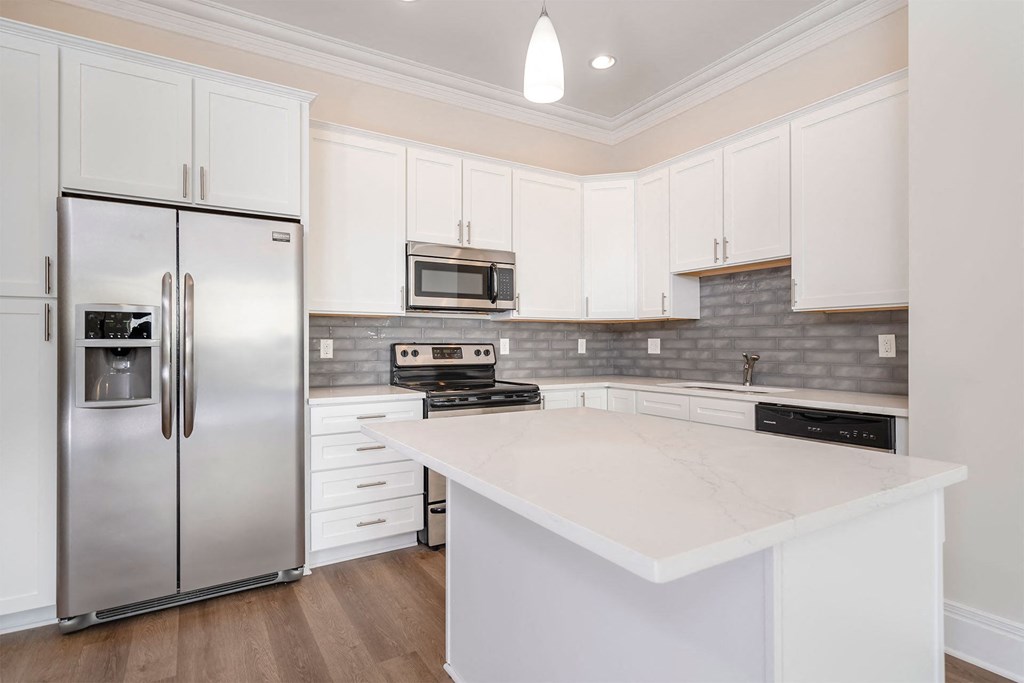 a kitchen with white cabinets and stainless steel appliances