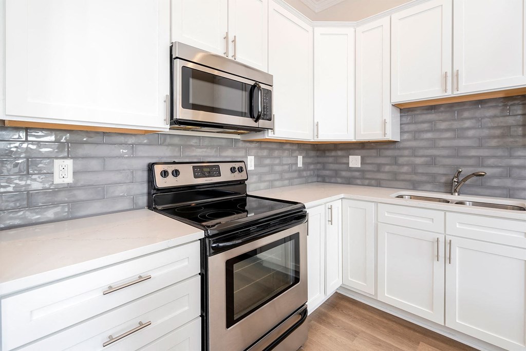 a kitchen with white cabinets and stainless steel appliances