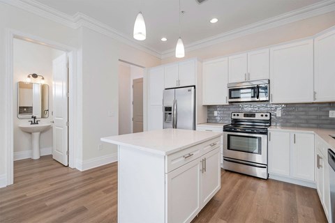 an open kitchen with white cabinets and stainless steel appliances