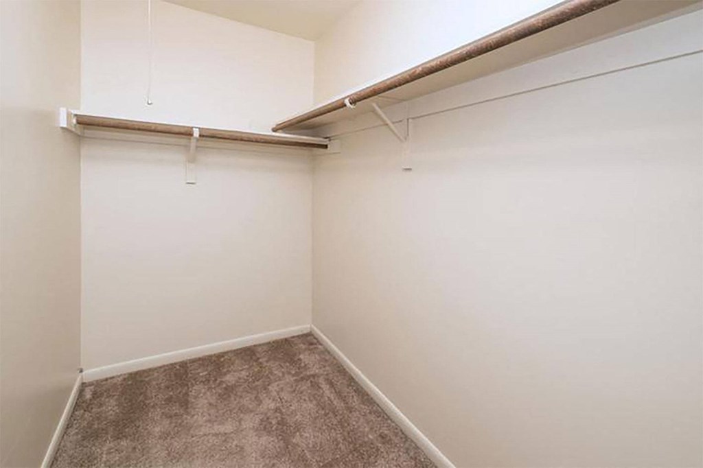an empty room with a wall hung closet and a carpet