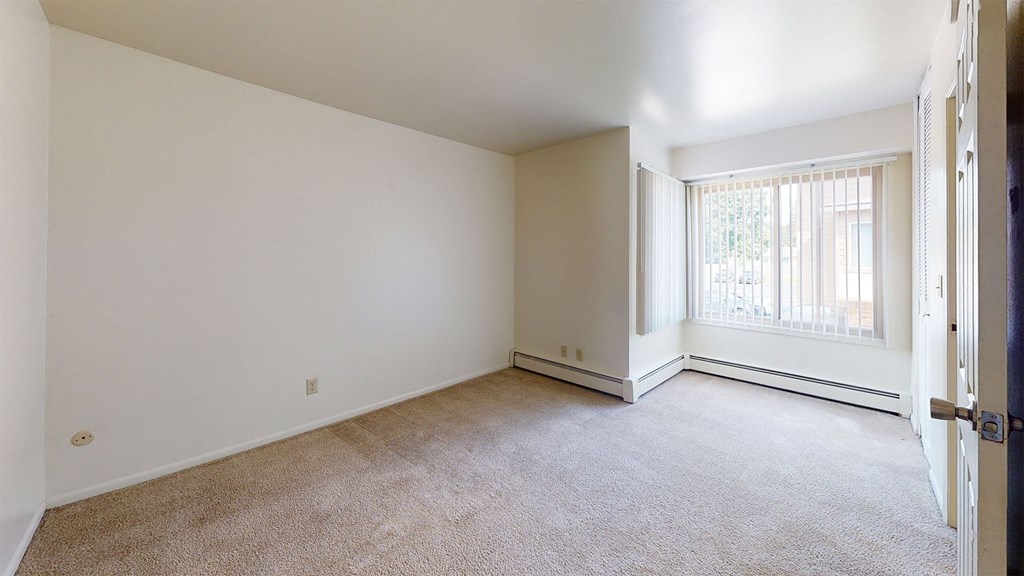 an empty room with a window and a door