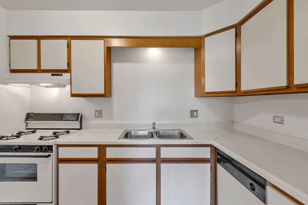 a kitchen with white cabinets and white countertops