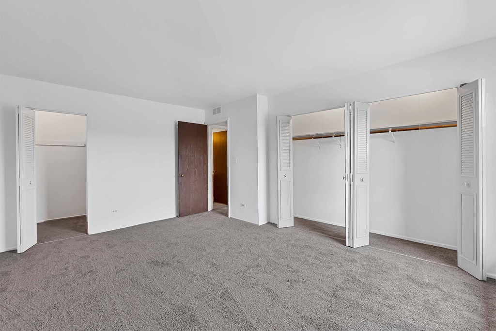 a bedroom with white walls and carpet