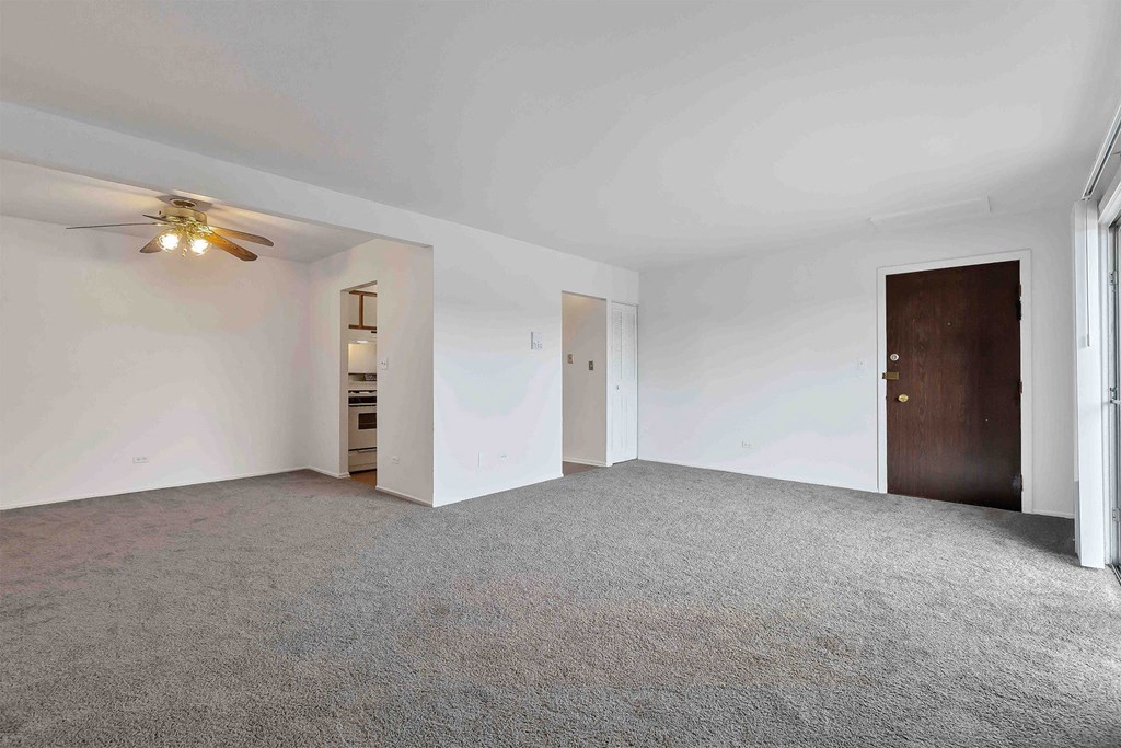 an empty bedroom with a ceiling fan