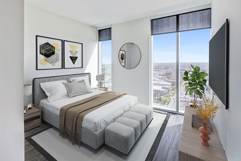 A modern bedroom with a large bed and a view of the city.