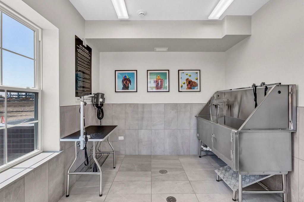 a patient room with a large silver tub and a window