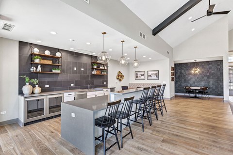 a kitchen with a large island and chairs in front of a table