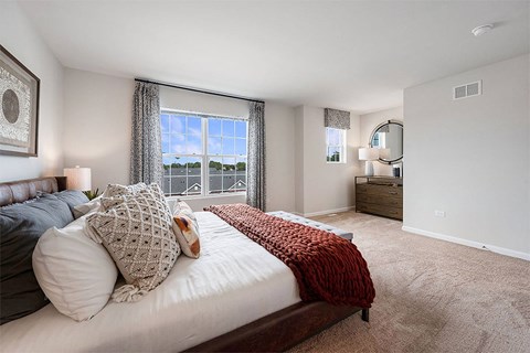 a bedroom with a large window and a bed