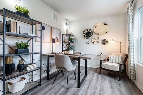 a home office with a desk and a chair and a window