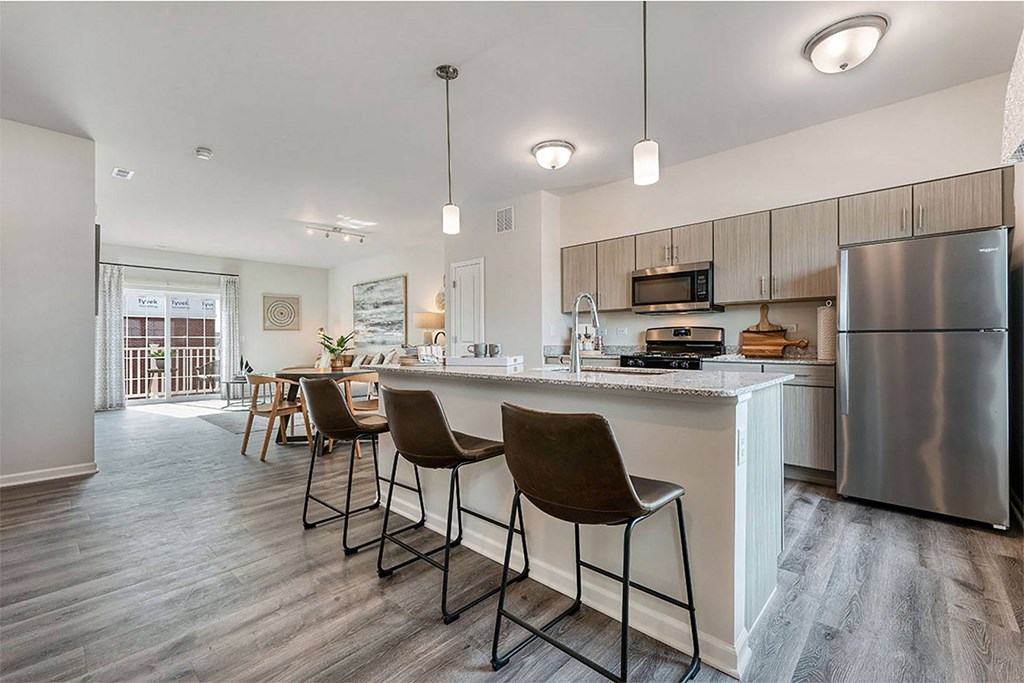 a kitchen with a bar and a stainless steel refrigerator