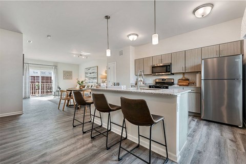 a kitchen with a bar and a stainless steel refrigerator