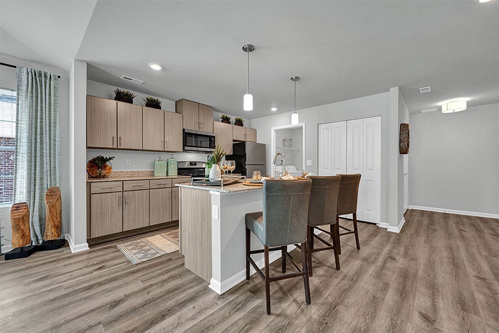 a kitchen with a bar and chairs in a room