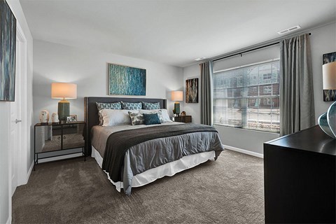 a bedroom with a large window and a bed