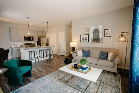 A living room with a white couch and a green chair.
