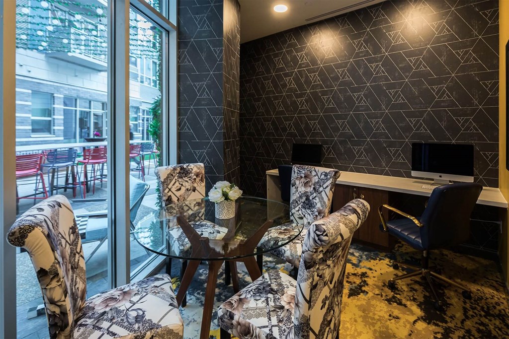A room with a glass table and chairs with a patterned design.